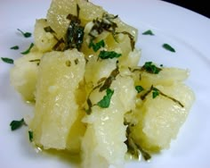 a white plate topped with potatoes and herbs