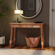 a wooden table with a basket underneath it and a round mirror on the wall above it