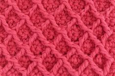 close up view of the crochet stitchs on a pink knitted blanket