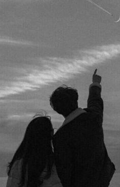 a man and woman flying a kite on the beach