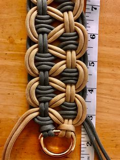 a close up of a piece of cloth with a metal ring on it and measuring tape in the background