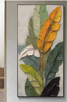 a painting with yellow and green leaves hanging on the wall in front of a door