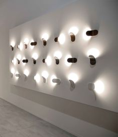 a large white wall with lots of lights on it's sides and several circular holes in the wall