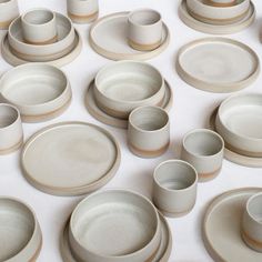 a table topped with lots of white dishes and cups