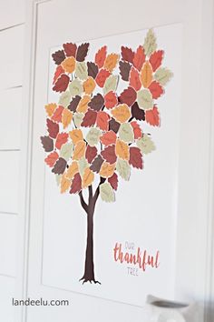 a tree made out of leaves is shown on the wall in front of a vase