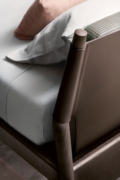 a bed with two pillows on top of it next to a wooden headboard and foot board