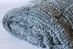 a pile of gray towels sitting on top of a white table