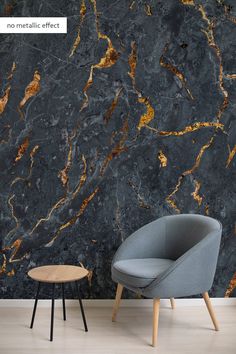 a chair and table sitting in front of a wall with gold marble effect on it