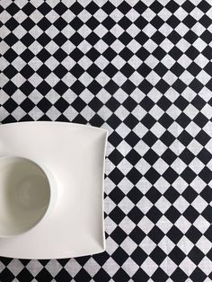 a black and white checkered table cloth with a bowl on it