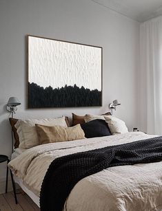 a bedroom with white walls and wooden flooring has a black blanket on the bed