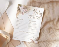 a pink and gold baby dedication card on top of a white blanket with satin ribbons