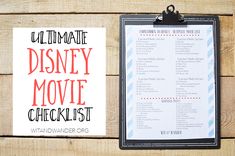 the ultimate disney movie checklist is displayed next to a clipboard on a wooden table