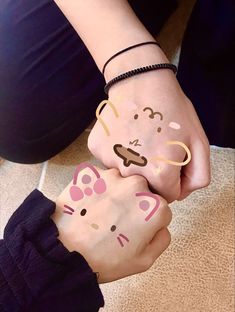 two people holding hands with painted faces on their fingers and wristbands, both wearing bracelets