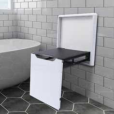 a white bath tub sitting next to a black and white sink under a window in a bathroom