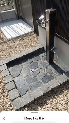 an open door on the side of a building next to a stone walkway and steps