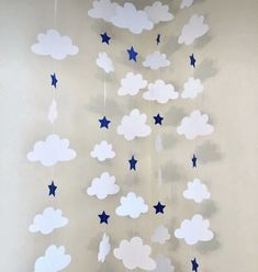 a crib mobile with stars and clouds hanging from it's sides on a wall