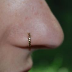 a woman's nose with a tiny gold ring on it