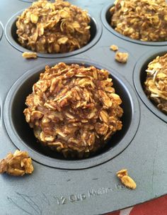 several muffins in a cupcake pan with some oats on the top