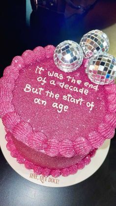 a pink cake with disco balls on top that says it was the end of a decade but the start of an age