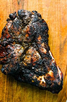 a piece of meat that is sitting on top of a wooden cutting board and has been grilled