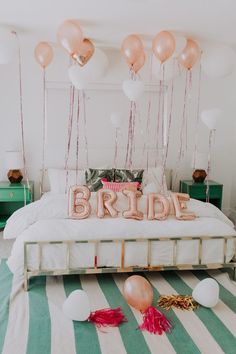 a bed with balloons and a bride sign on it