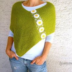 a woman wearing a green knitted sweater with daisies on it