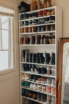 a white shelf filled with lots of pairs of shoes