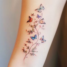 a woman's arm with butterflies and vines on the back of her body,