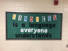 a green sign that says kindness is a language everyone understands