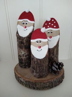 three wooden logs with santa hats on them