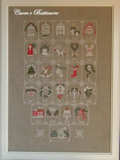 a cross stitch christmas sample in a white frame