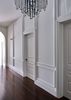 an empty room with white walls and wood floors