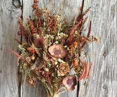 an arrangement of dried flowers on a wooden surface