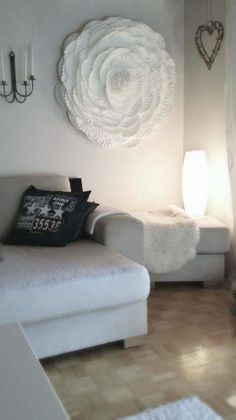 a white couch sitting in a living room next to a lamp