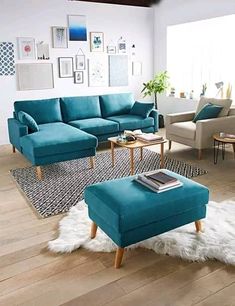 a living room with blue couches and white rugs on the wooden flooring