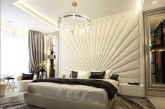 a large white bed sitting in a bedroom next to a chandelier and window