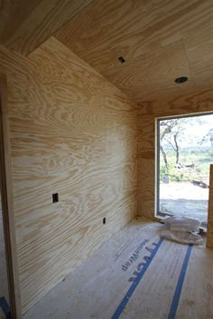 an unfinished room with wood paneling on the walls and windows in place for insulation