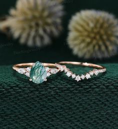 two gold rings with green and white stones on the sides, one is made from 18k rose gold