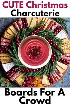 round Christmas charcutierie board with meats, cheese, and dried fruit and a wreath of rosemary and fresh cranberries surrounding a bowl of cranberry dip in the middle