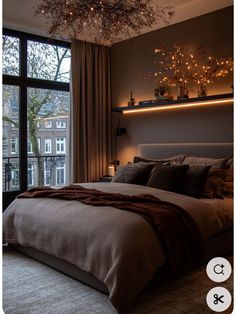 a bedroom with a large bed and lights on the wall above it's headboard