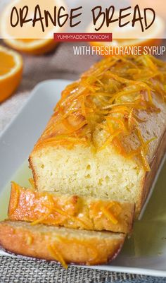 an orange bread with fresh orange syrup on top is sitting on a plate next to sliced oranges