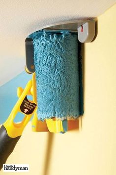 there is a blue towel hanging on the wall next to a pair of yellow scissors