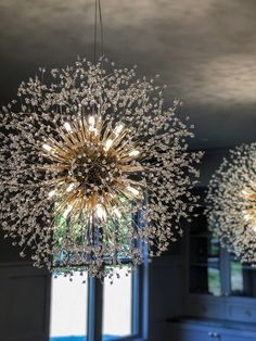 two chandeliers hanging from the ceiling in a room