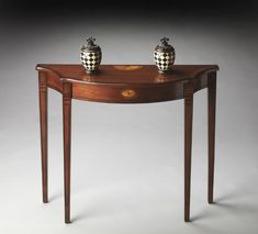 a wooden table with two vases on it's top and the bottom shelf