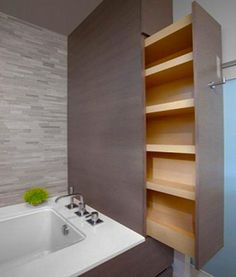 a bathroom with a sink, mirror and shelving unit