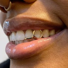 a close up of a woman's mouth with a gold ring on it