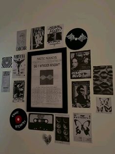 a white wall covered in various records and stickers