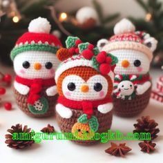 small crocheted snowmen with hats and scarves on their heads sitting next to pine cones