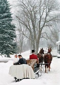 people are riding in a horse drawn carriage through the snow with two men and a woman