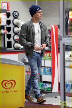 a man is walking down the street wearing a beanie